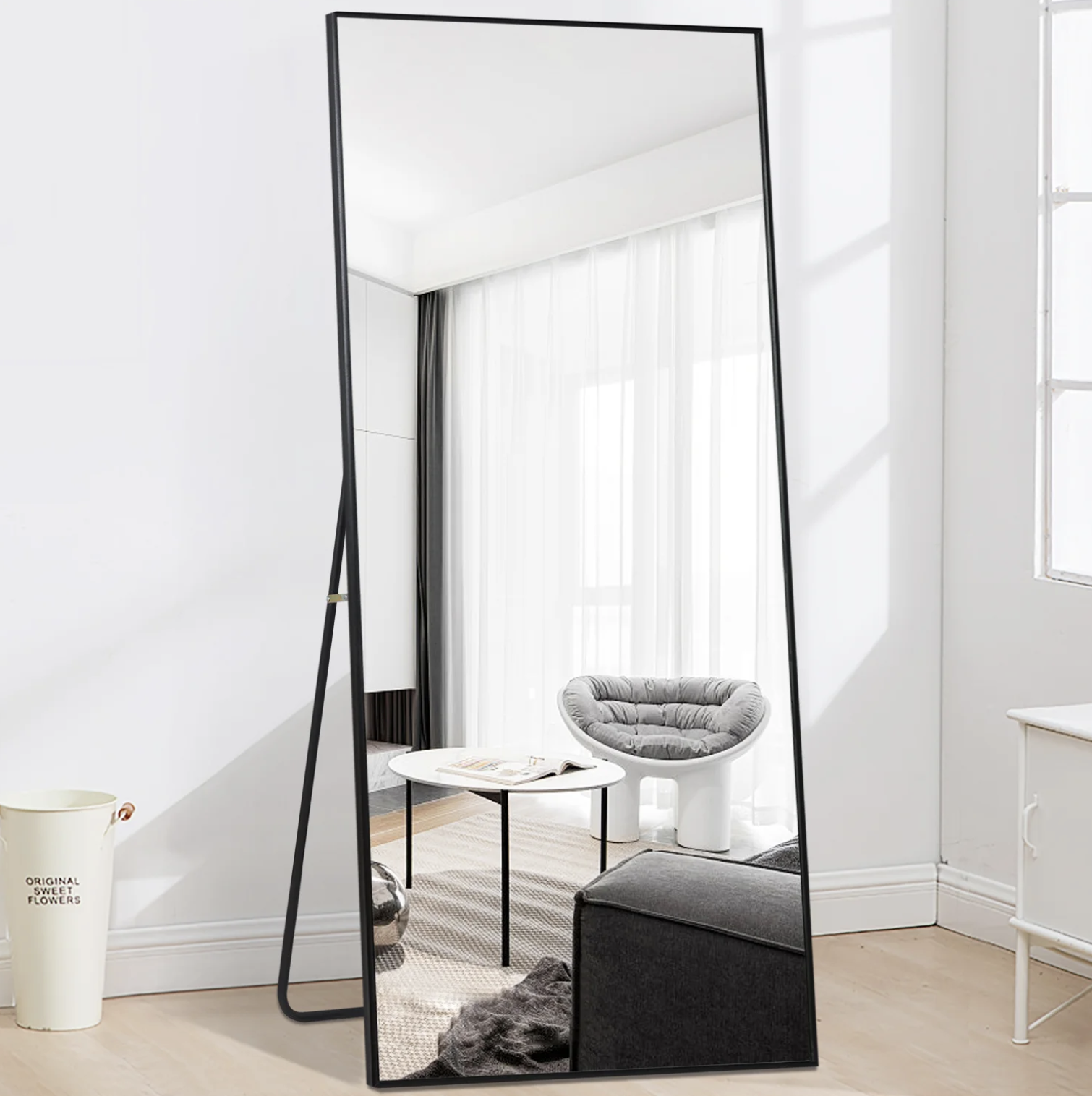 The mirror reflecting a living room with a chair, table, and couch in it