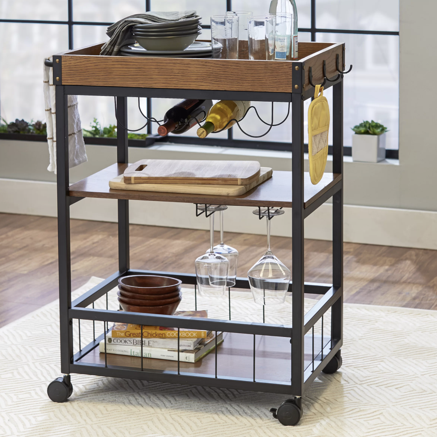 The bar cart with glasses, wine, cutting boards, and cookbooks on it
