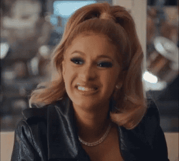 A woman raising her eyebrows and smiling through gritted teeth