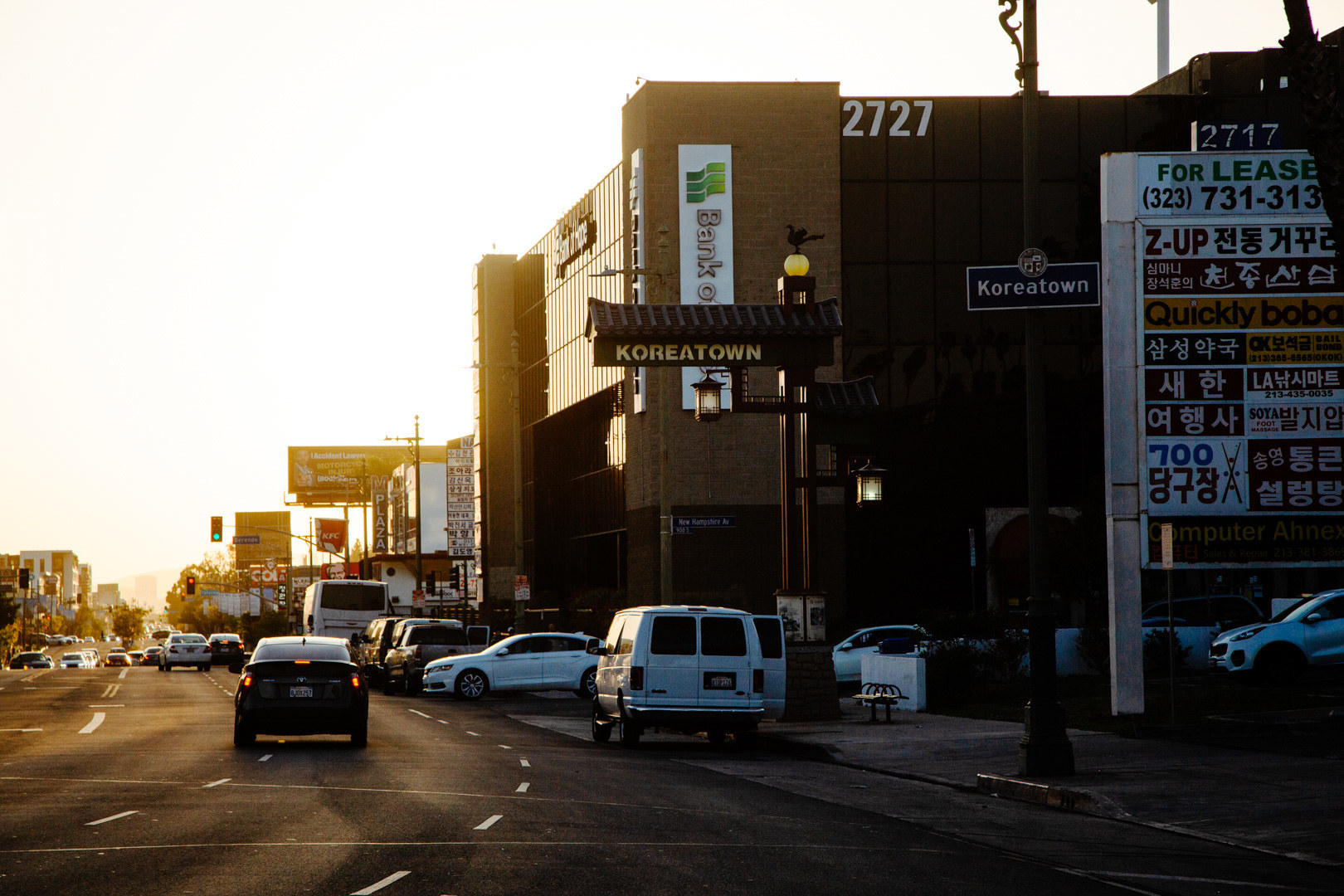 Cars pass by a sign reading Koreatown