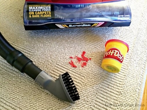 Blogger&#x27;s photo of a vacuum cleaner, a brush attachment, and Play-Doh on the carpet