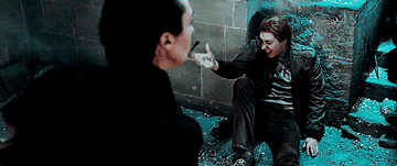 A slow-mo gif of Fred sitting against a blown-apart wall, his wand flying out of his hand