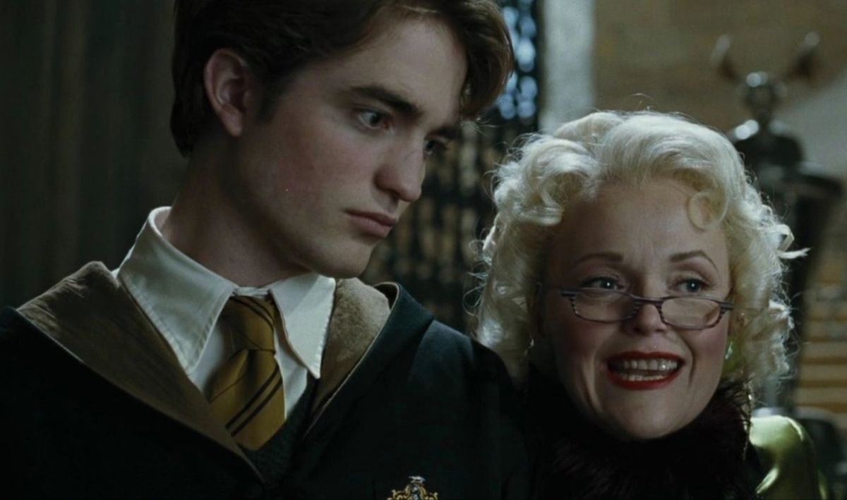 Cedric Diggory looking blank while Rita Skeeter stands next to him looking eager