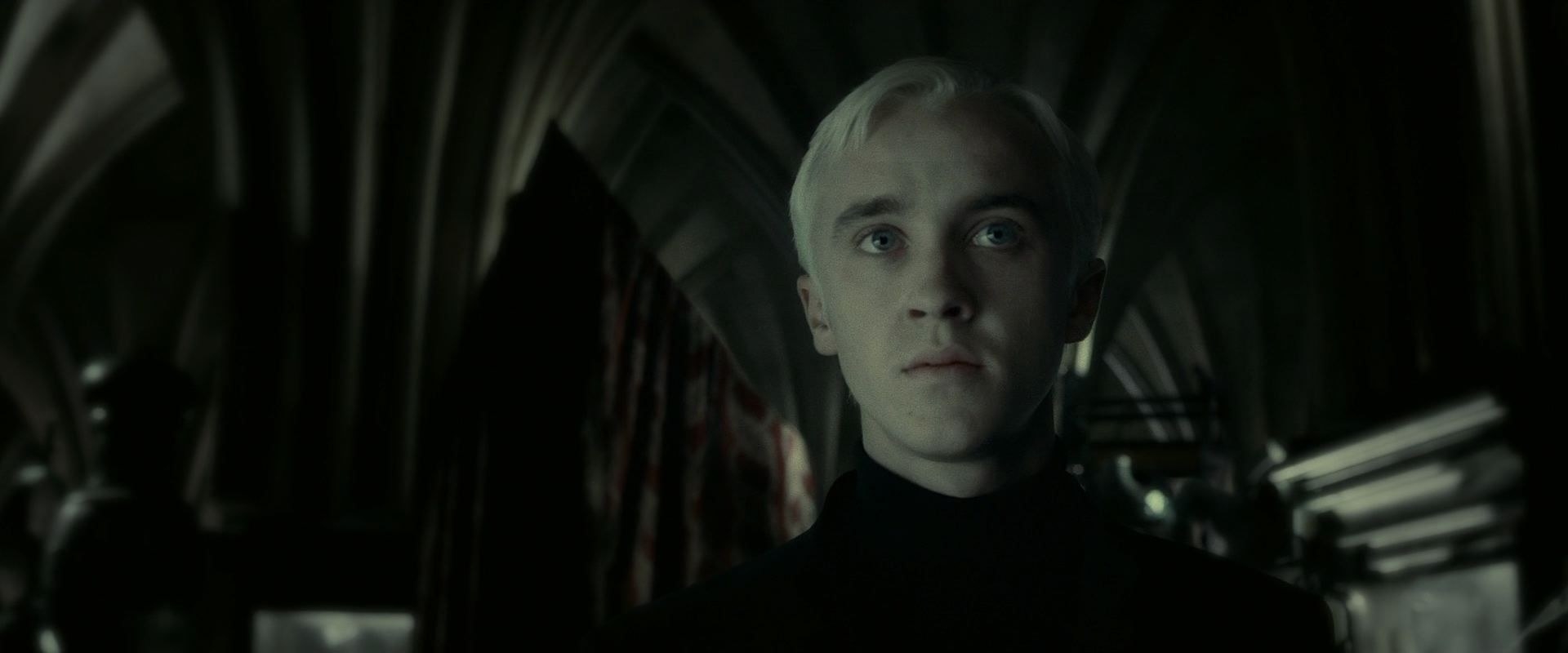 A closeup of Draco Malfoy looking pale and somber