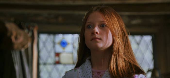 Young Ginny Weasley standing in a kitchen looking shocked