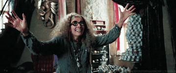 Professor Trelawny grinning and raising her arms above her head
