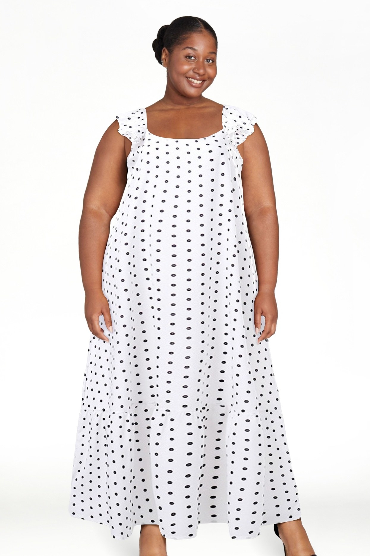 Woman in a sleeveless polka dot dress, smiling at the camera
