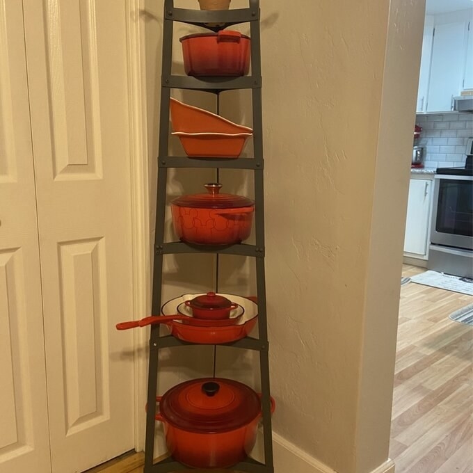 a reviewer photo of the rack filled with red cookware