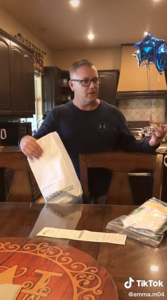 The father presenting the receipt for birth control with balloons in the background