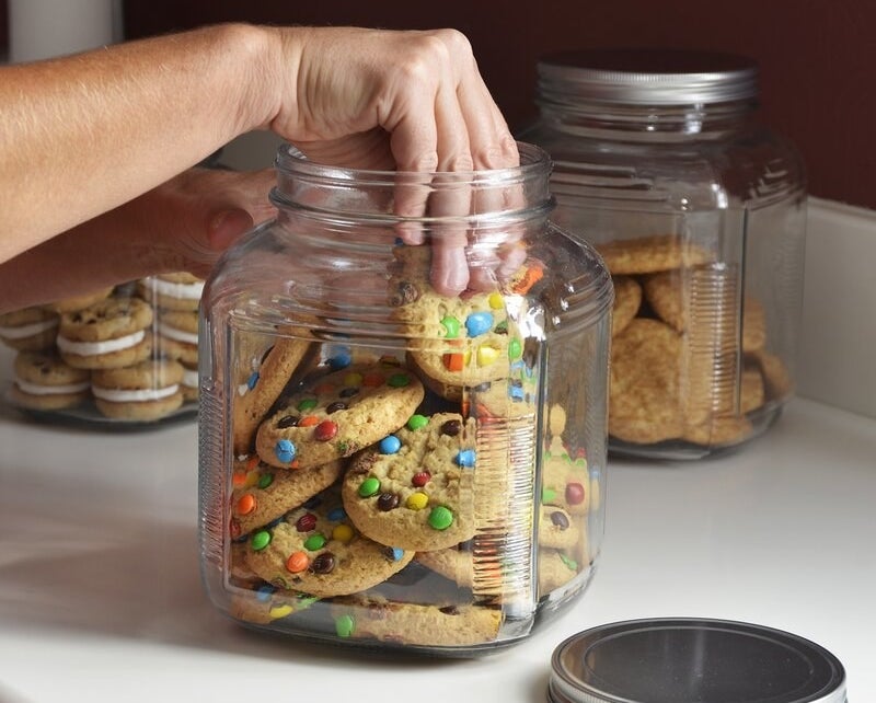a model grabbing a cookie from one of the glass jars