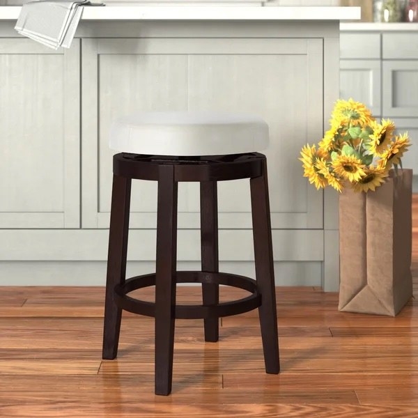 The stool next to some flowers in a kitchen