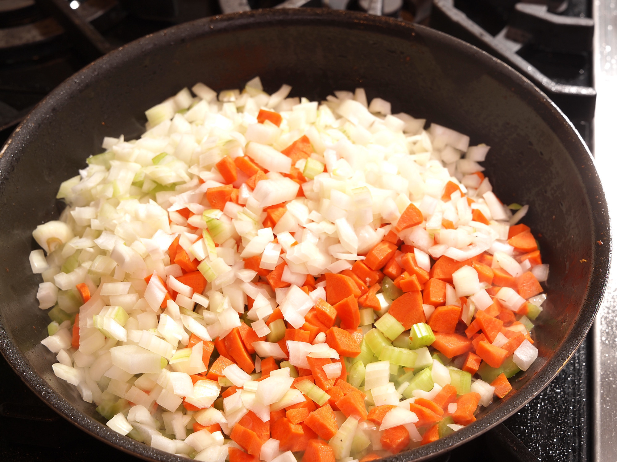 Diced carrot, celery and onion (mirepoix) in skillet on range