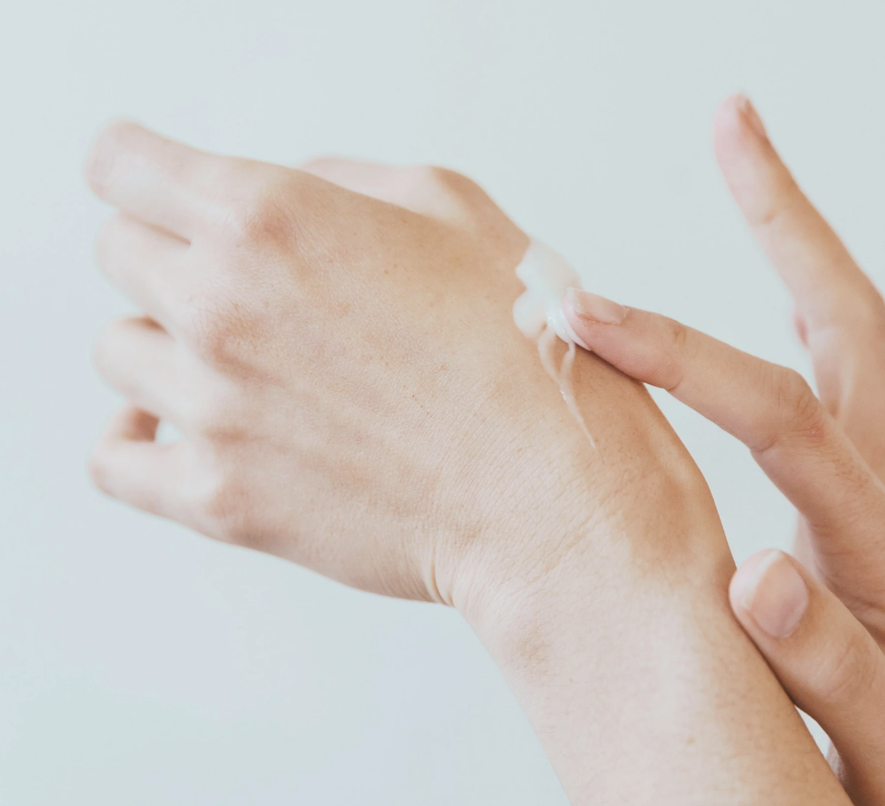 a person rubbing the cream serum into their hand