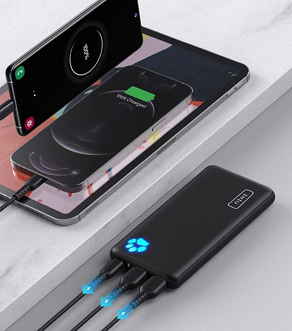 a portable power bank with three devices plugged into it