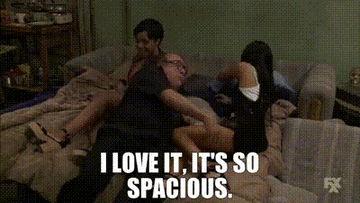 A GIF of a person lying on a futon saying I love it it&#x27;s so spacious