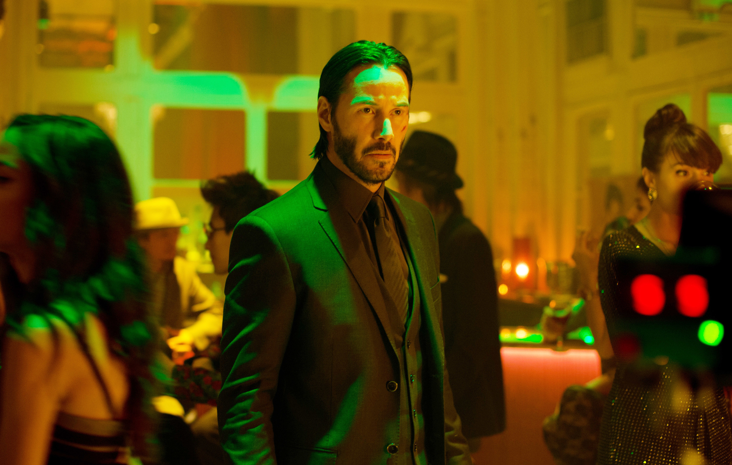 John Wick in a suit in the middle of a party