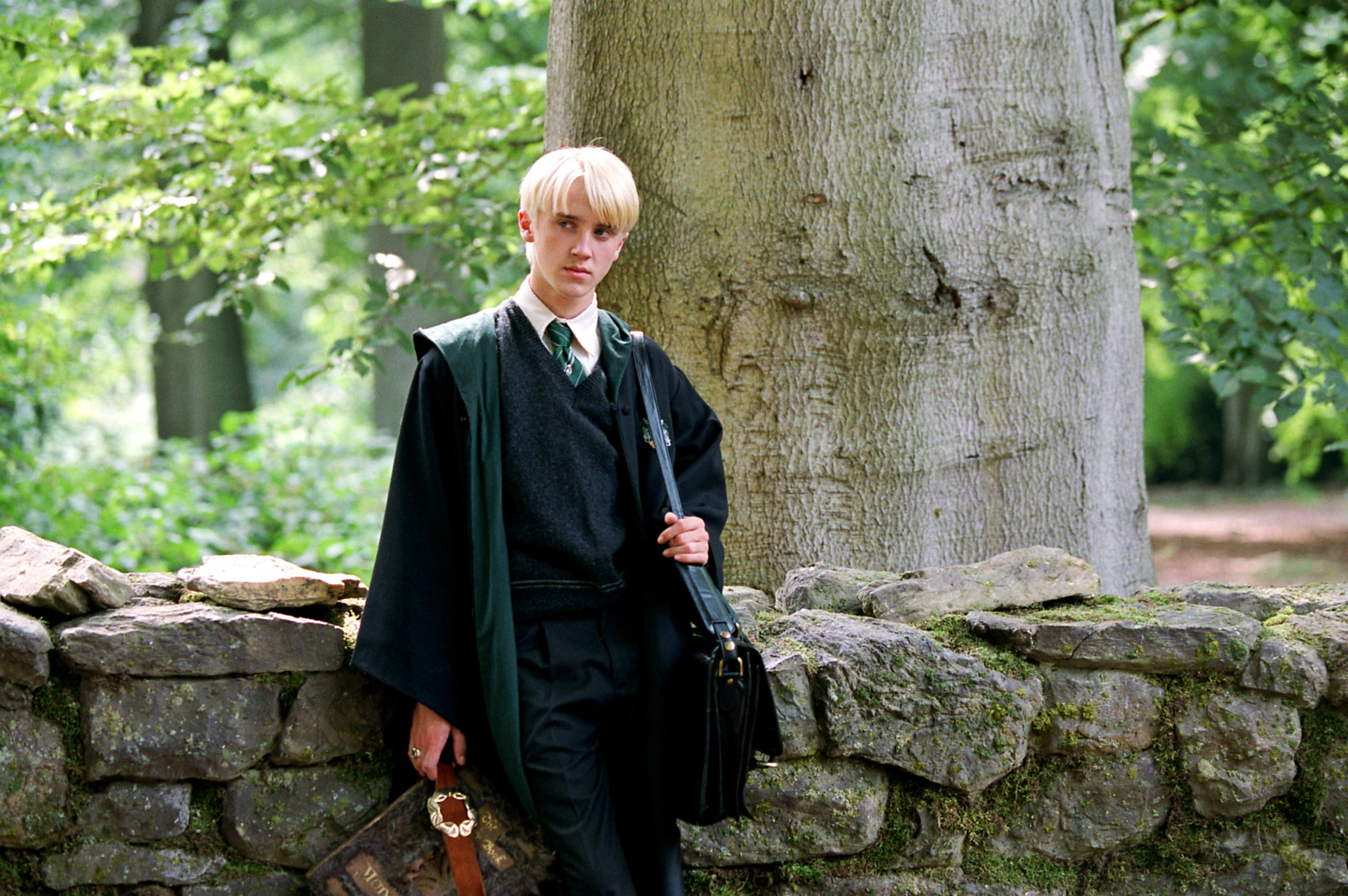 Felton as Malfoy standing outside with his book bag