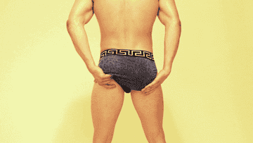 View from behind of a man in briefs and cupping each ass cheek