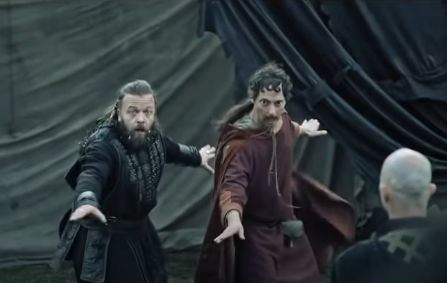 Kare Conradi as Orm and Tron Aurvag as Rufus dancing in front of a fellow Viking