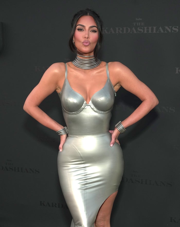 Kim Kardashian making a kiss expression with her hands on her hips