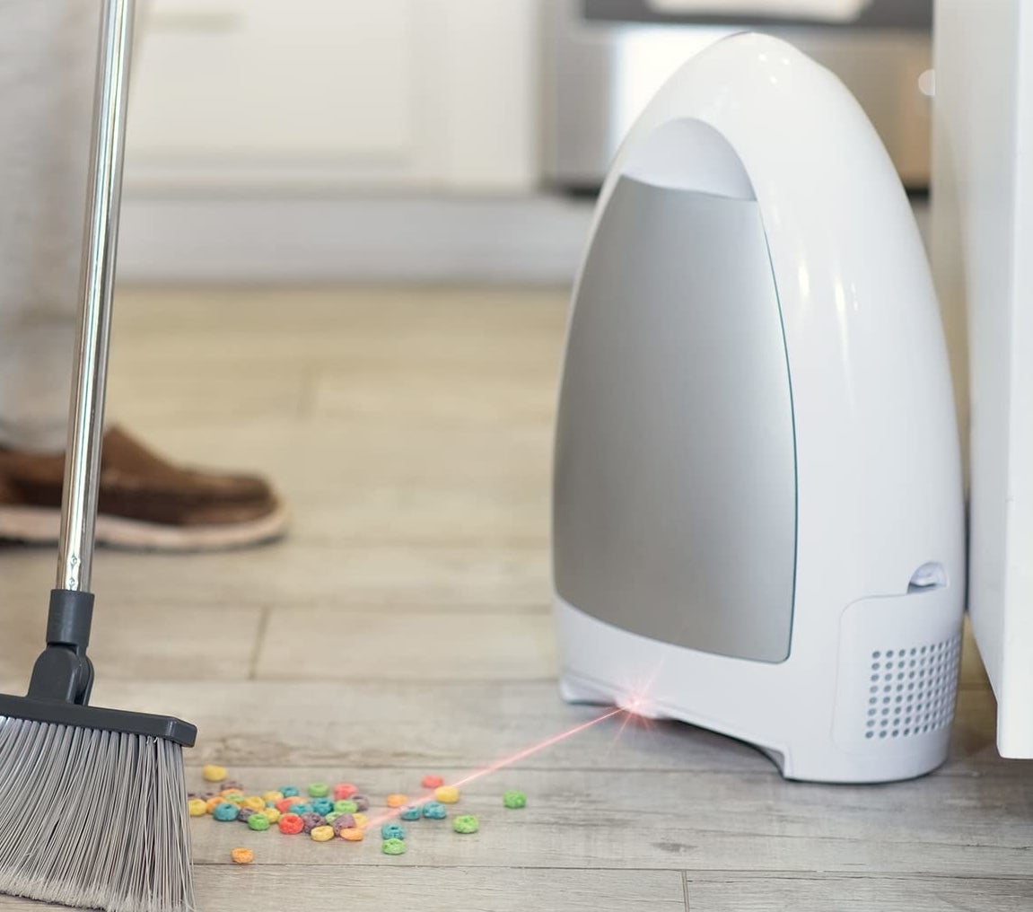 The vacuum about to suck up cereal on the floor