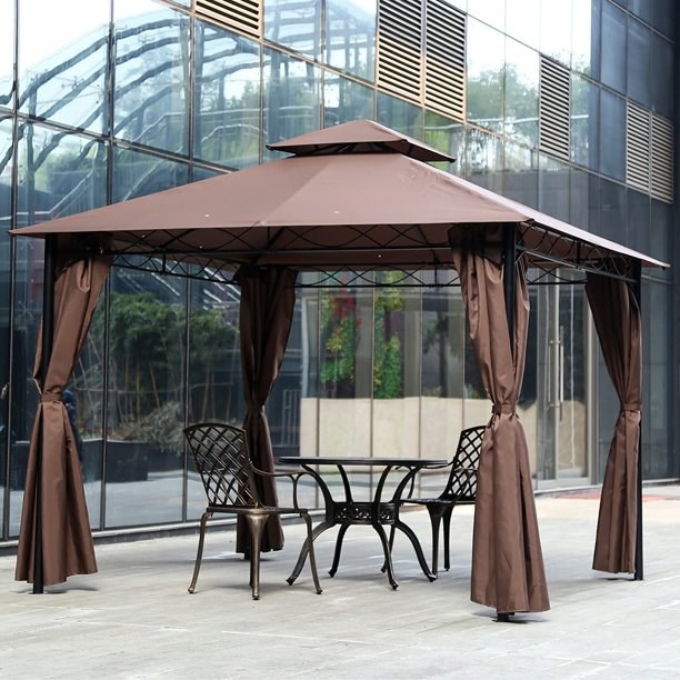 the brown canopy with a table and chairs underneath