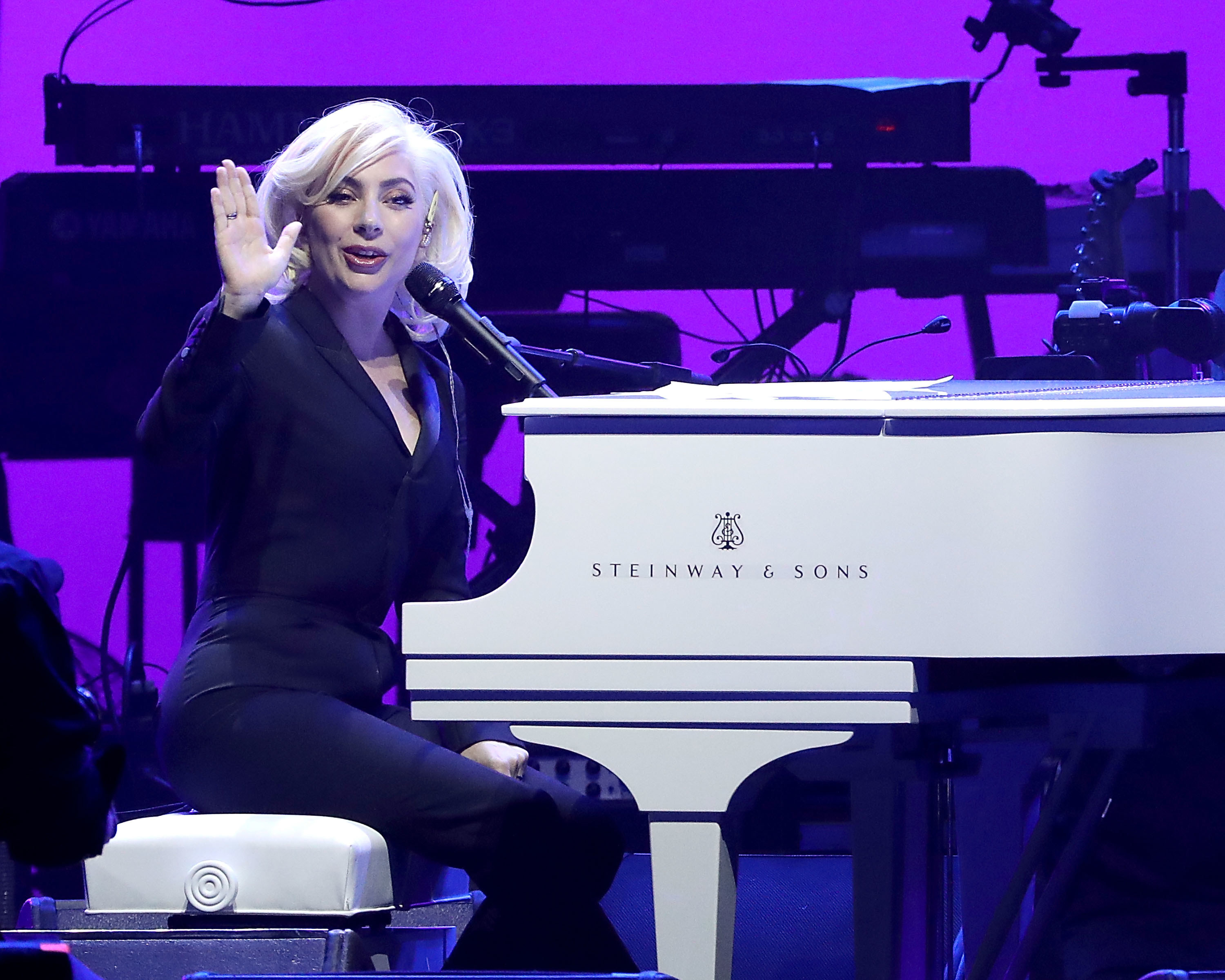 Lady Gaga playing a white piano