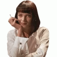 GIF of Uma Thurman with her hair in a black shoulder length bob, wearing a white shirt