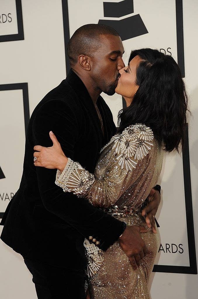 A close up of Kanye West as he kisses Kim Kardashian and grabs her butt