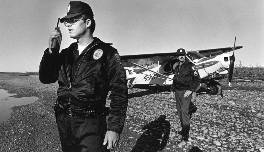 Cops standing near a helicopter on a beach