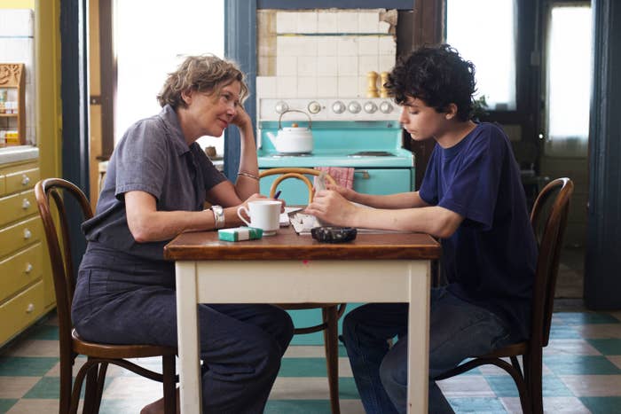 Anette Bening and Lucas Jade Zumann sit across a table from each other