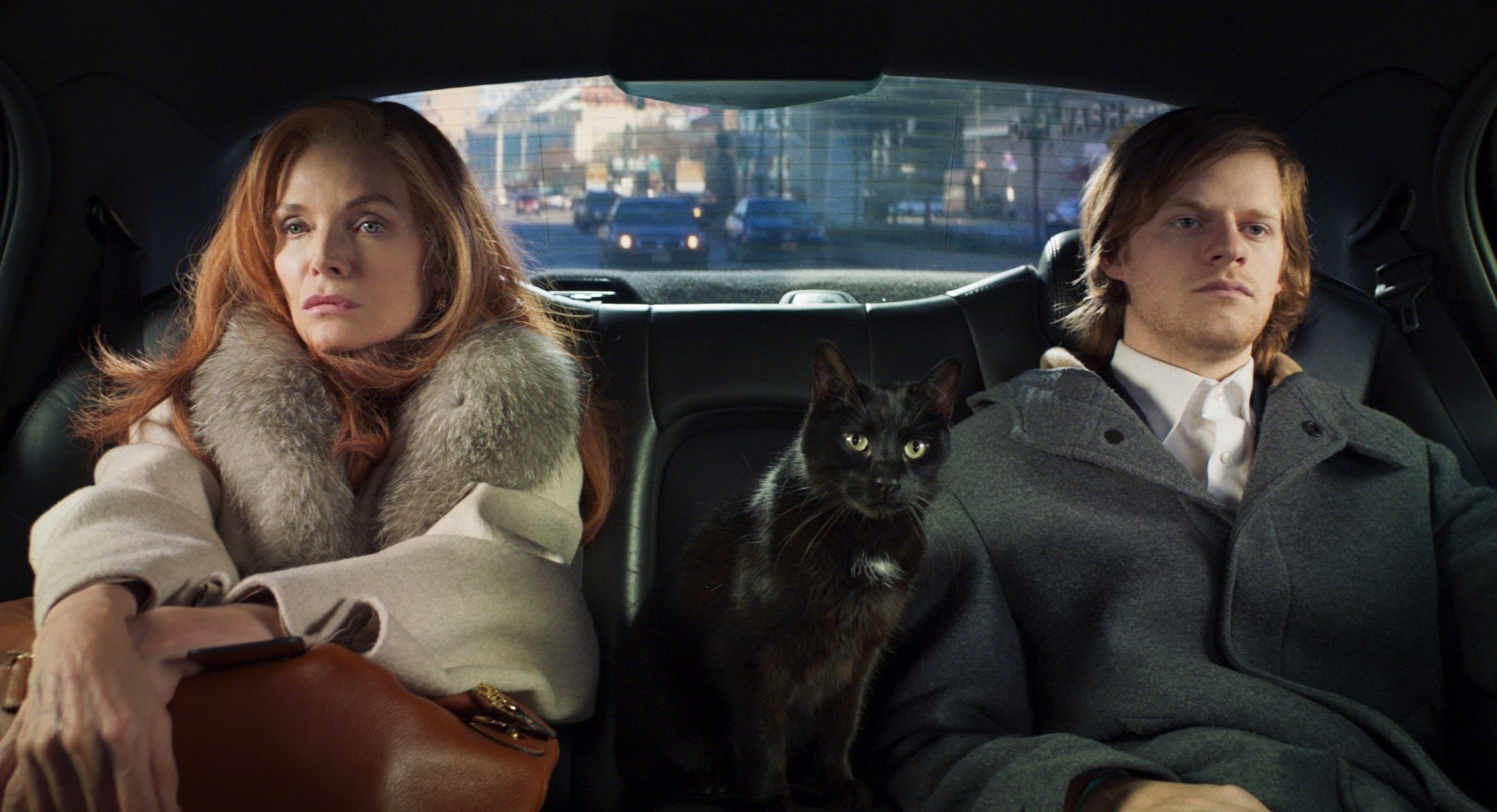 Michelle Pfeiffer and Lucas Hedges sit in the back of a car with a cat