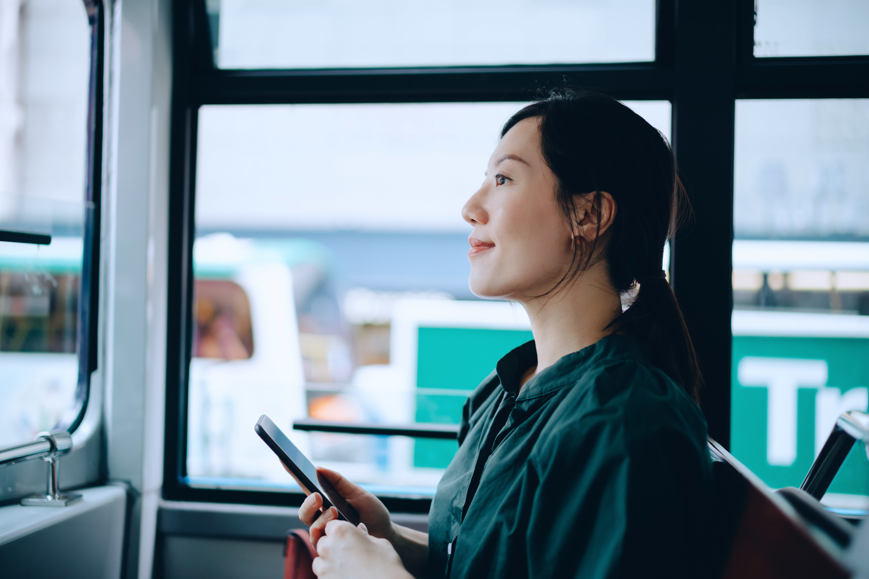 A woman on a train holding her phone