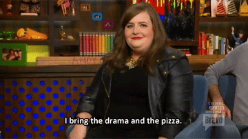 Aidy Bryant saying &quot;I bring the drama and the pizza&quot; while pivoting in a seat