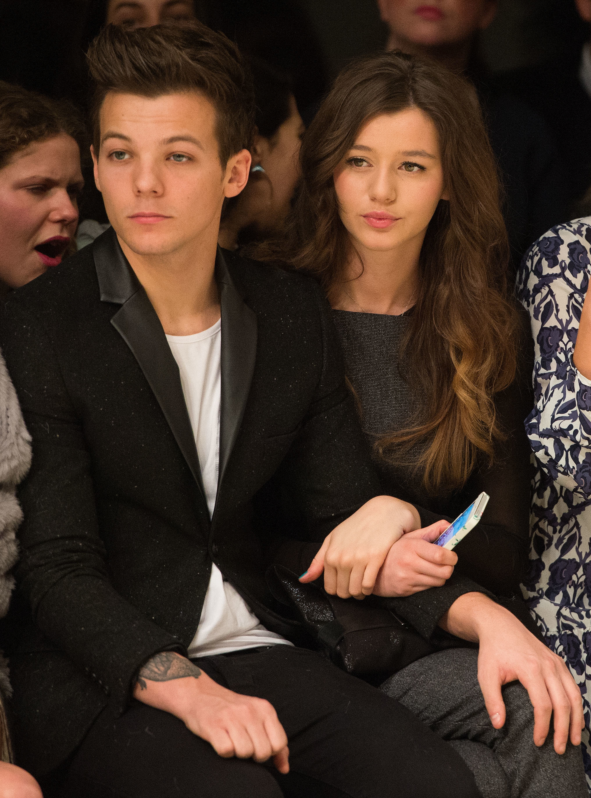 Louis Tomlinson of One Direction and Eleanor Calder attend the Topshop Unique show at the Tate Modern during London Fashion Week Fall/Winter 2013/14