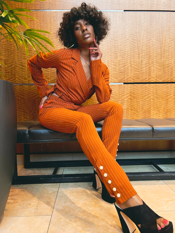 a model wearing the pinstripe two-piece set in orange
