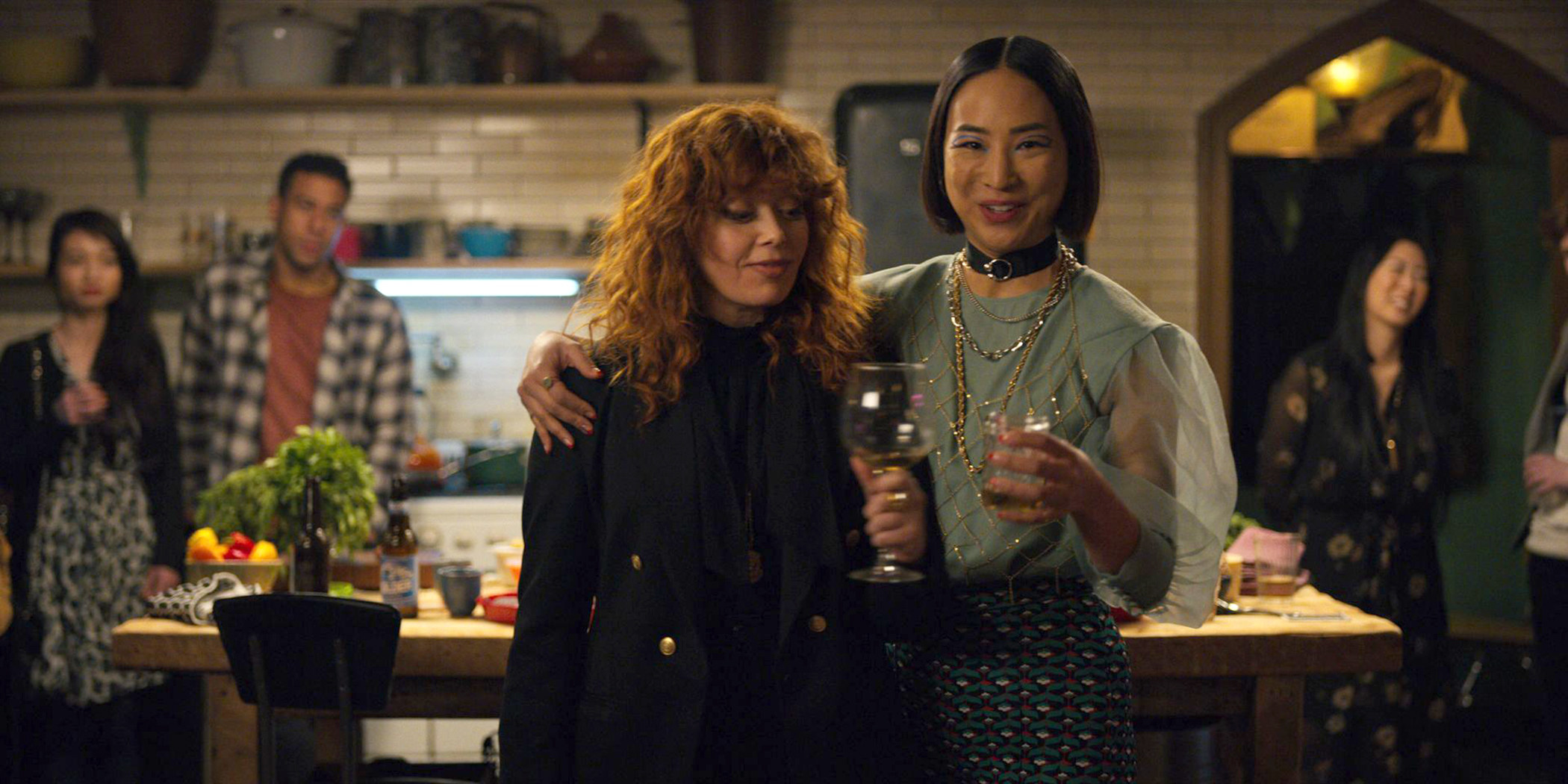 the characters of Russian Doll at a party with wine glasses in hand