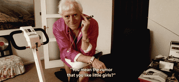 A GIF of Jimmy Savile with a cigar smiling at the camera with the text, &quot;You mean the rumour that you like little girls?&quot;
