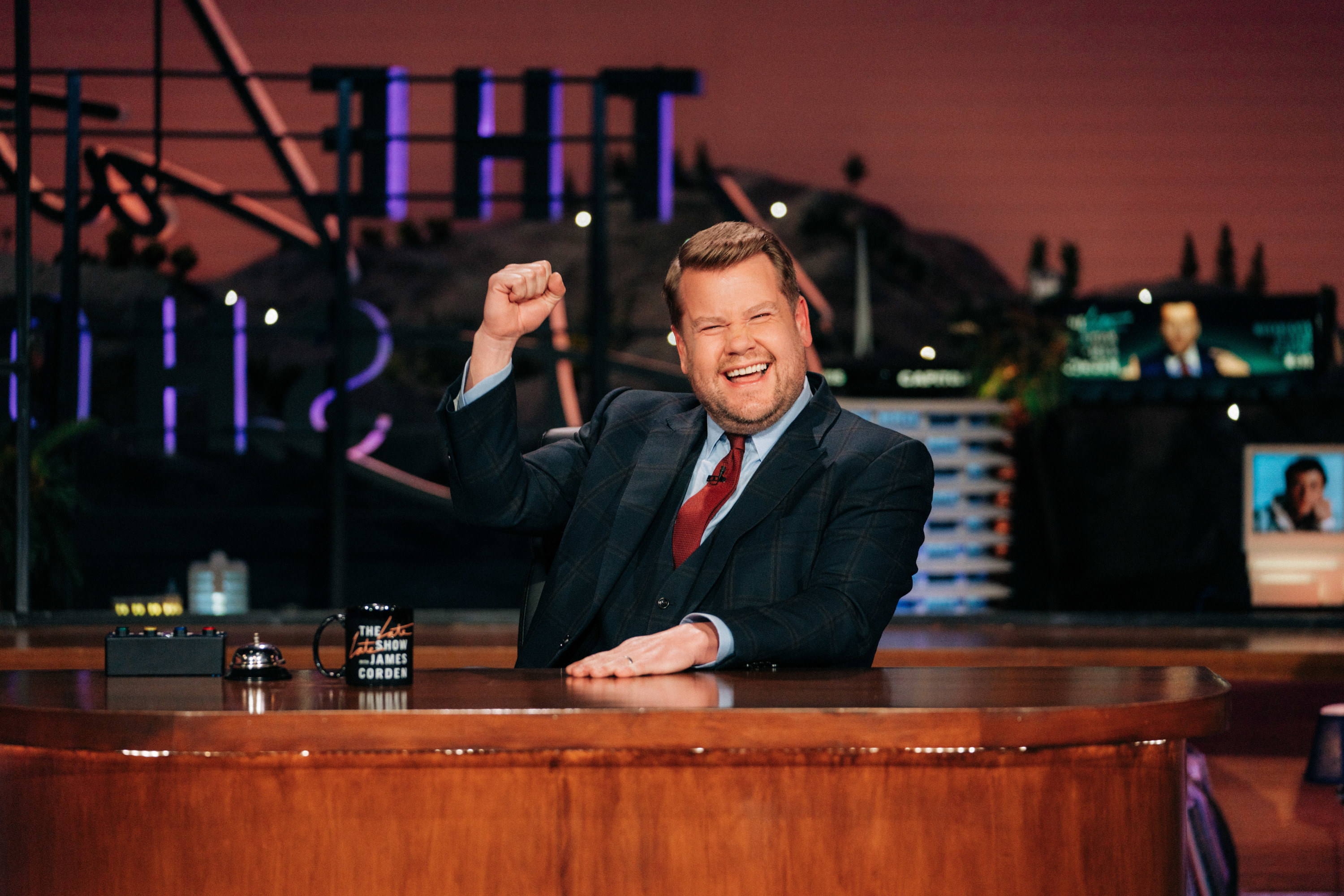 James smiling at his desk on the set