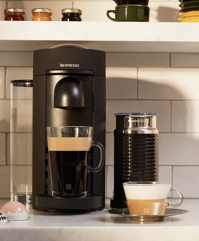 The Nespresso machine with two cups of foamy coffee