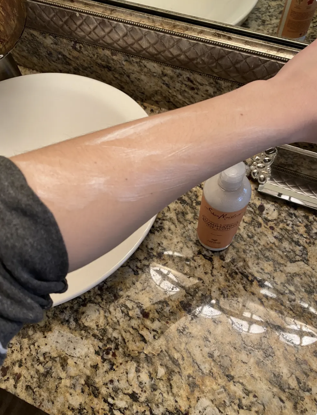 The author applying body lotion to her arm