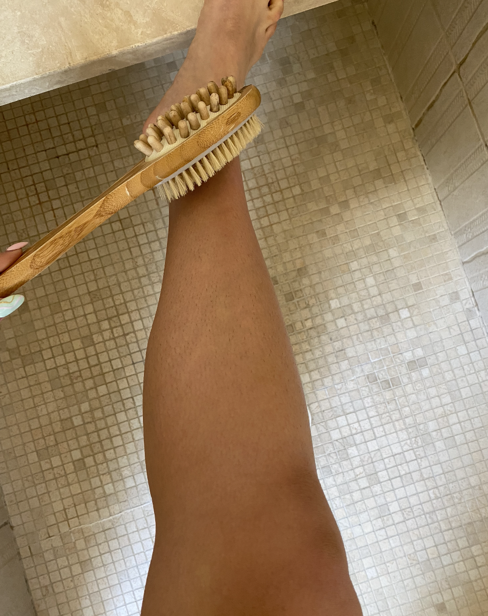 Author holding brush to her bare leg