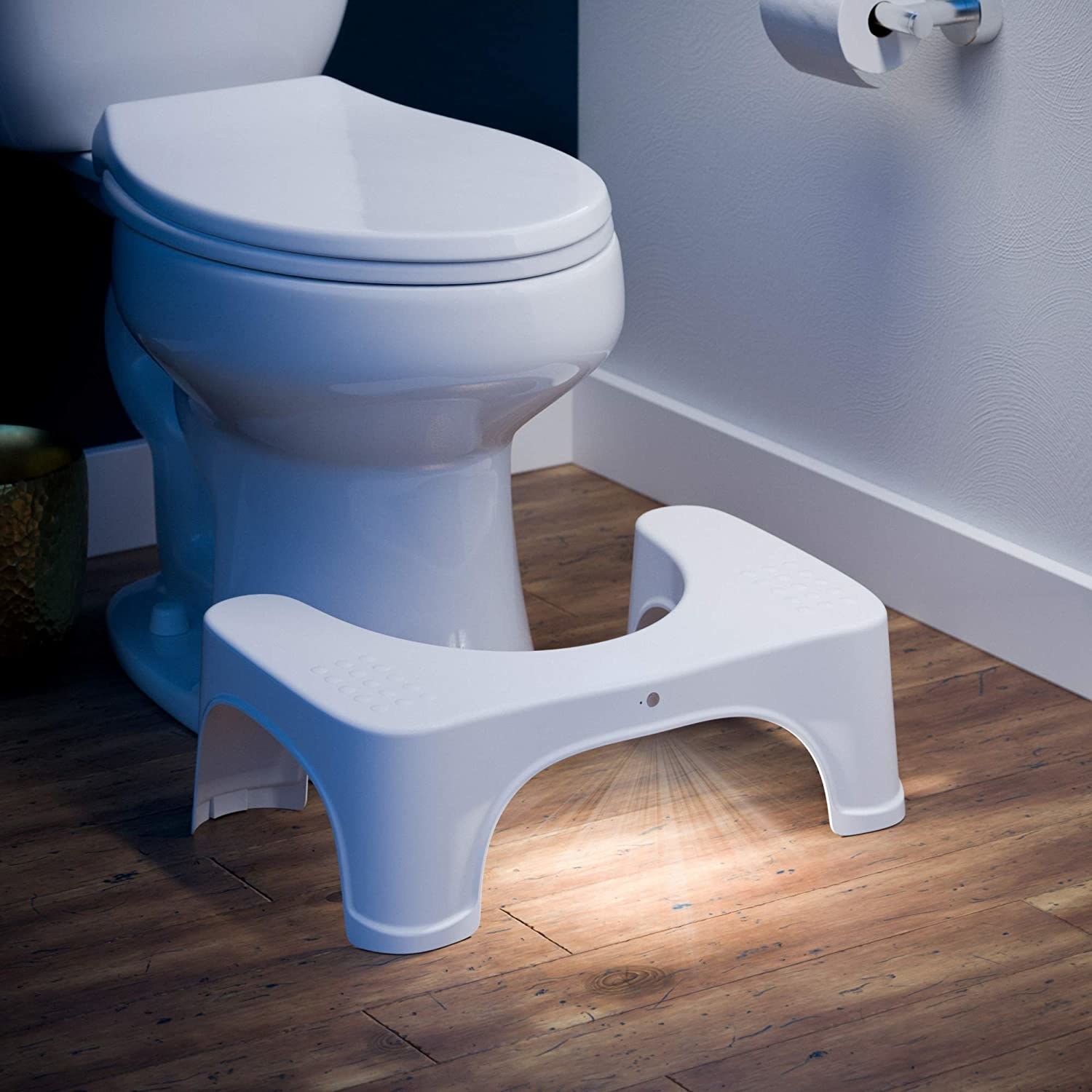 the Squatty Potty with the light on in front of a toilet
