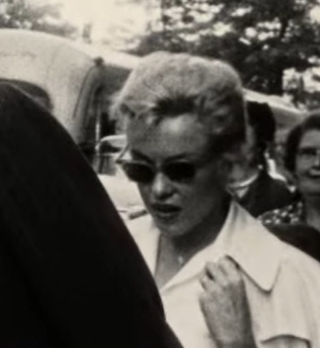 Marilyn is shown walking amongst a crowd in archival video footage
