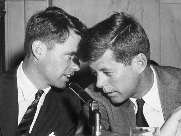 Bobby Kennedy whispers to his brother, John F. Kennedy, during a meeting