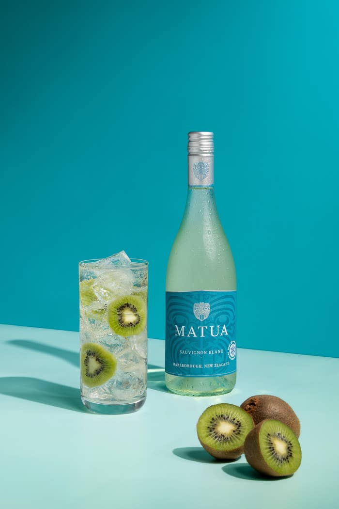 A glass of Matua Spritz over ice with kiwis.