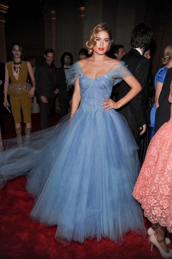 Doutzen wears a tulle dress with off the shoulder sleeves and a dreamy train