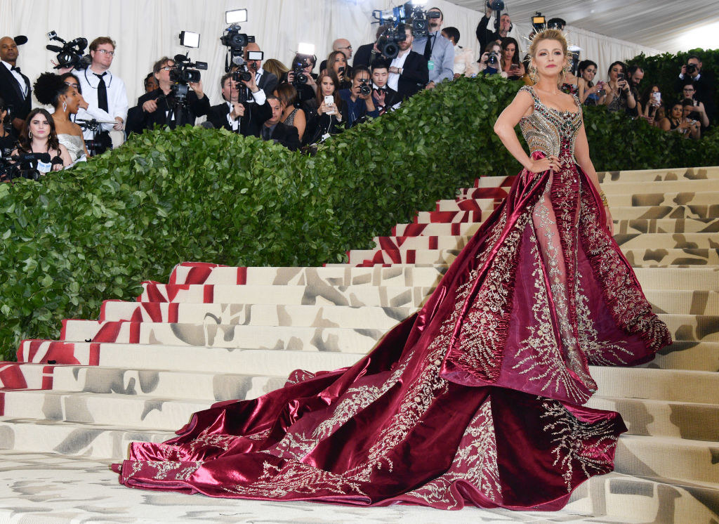 Blake wears a long renaissance style gown with a large train