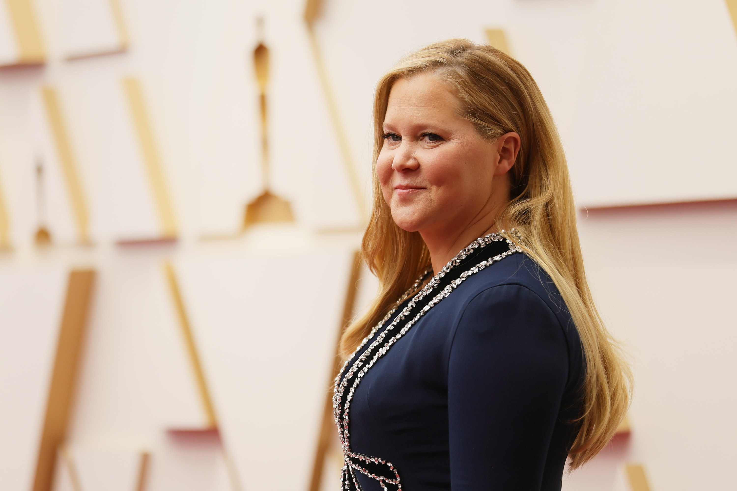 Amy smiles at an Oscars step-and-repeat