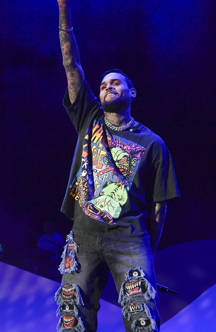 Chris Brown smiles on stage at a concert.
